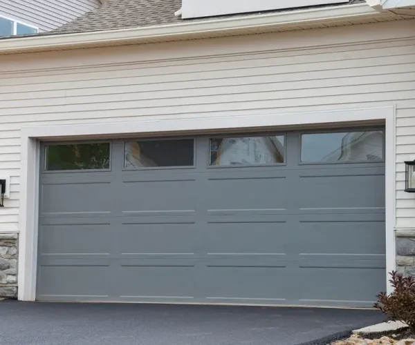 A modern garage door being replaced by a professional technician.